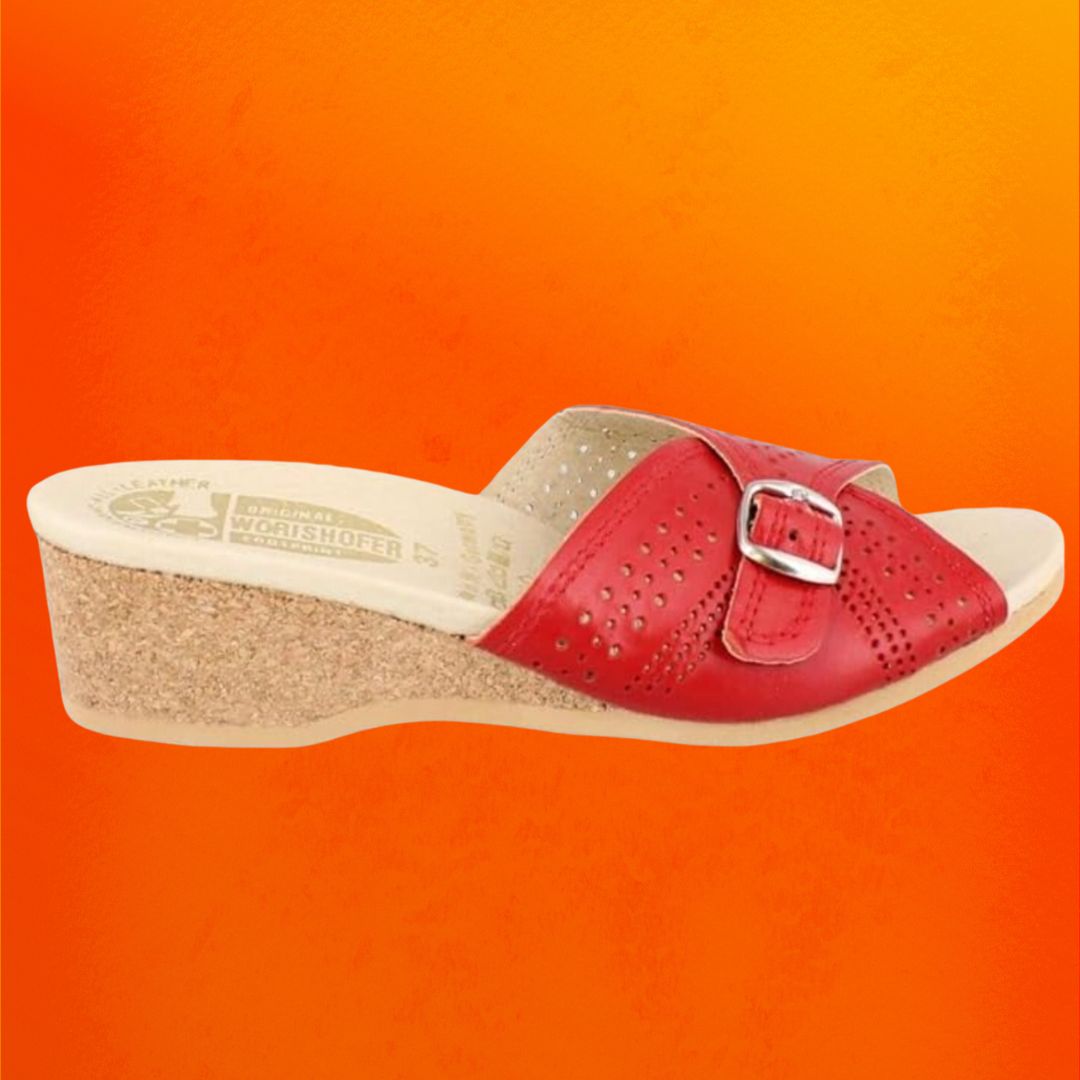 Red slide sandals with a cork sole against an orange background