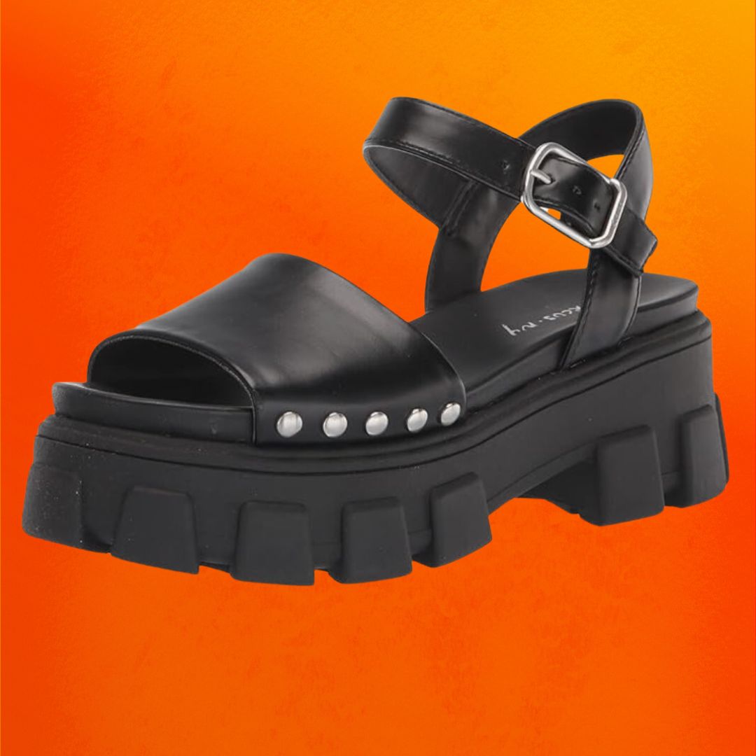 Chunky black sandals with an ankle strap against an orange background