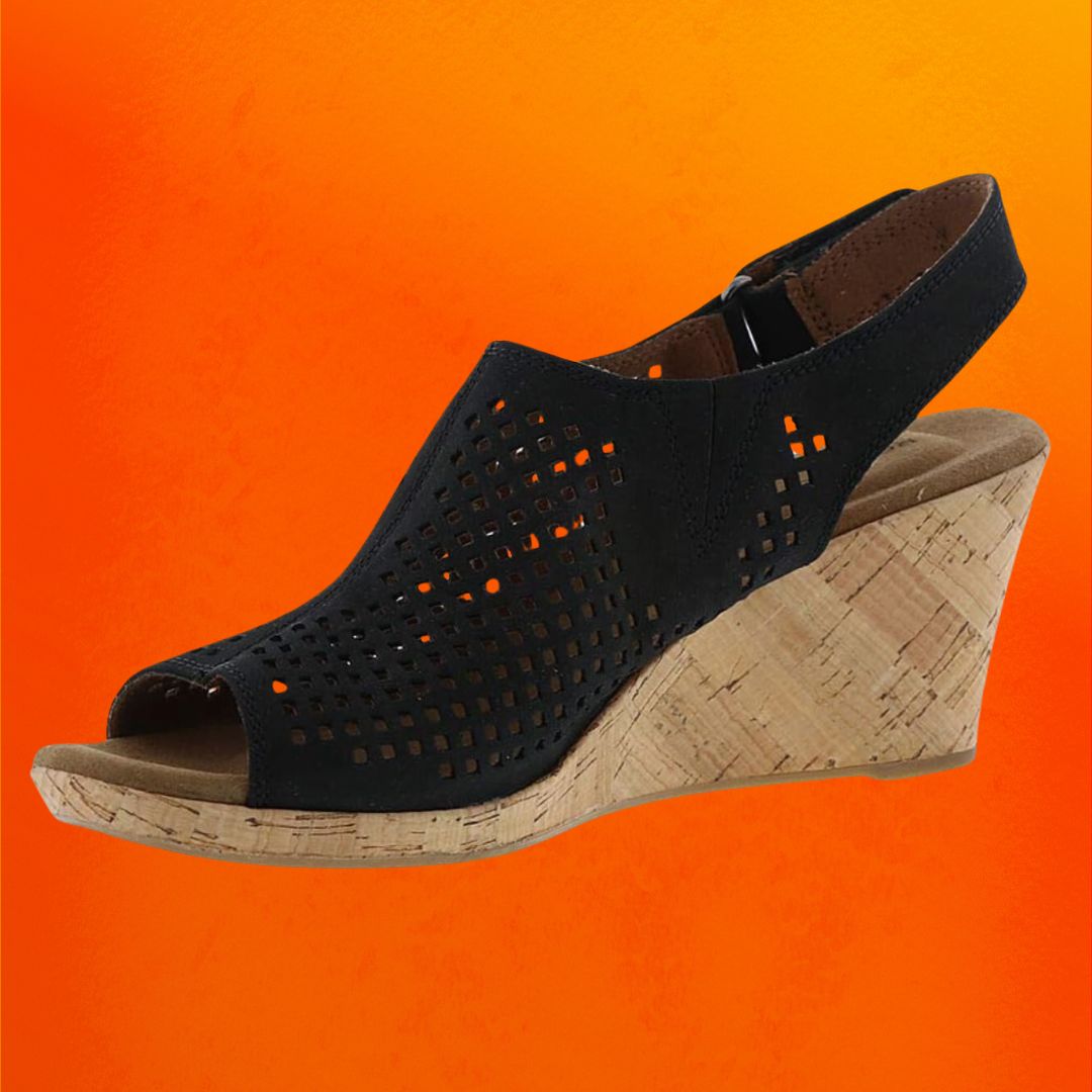 Black wedge sandals with a cork sole against an orange background