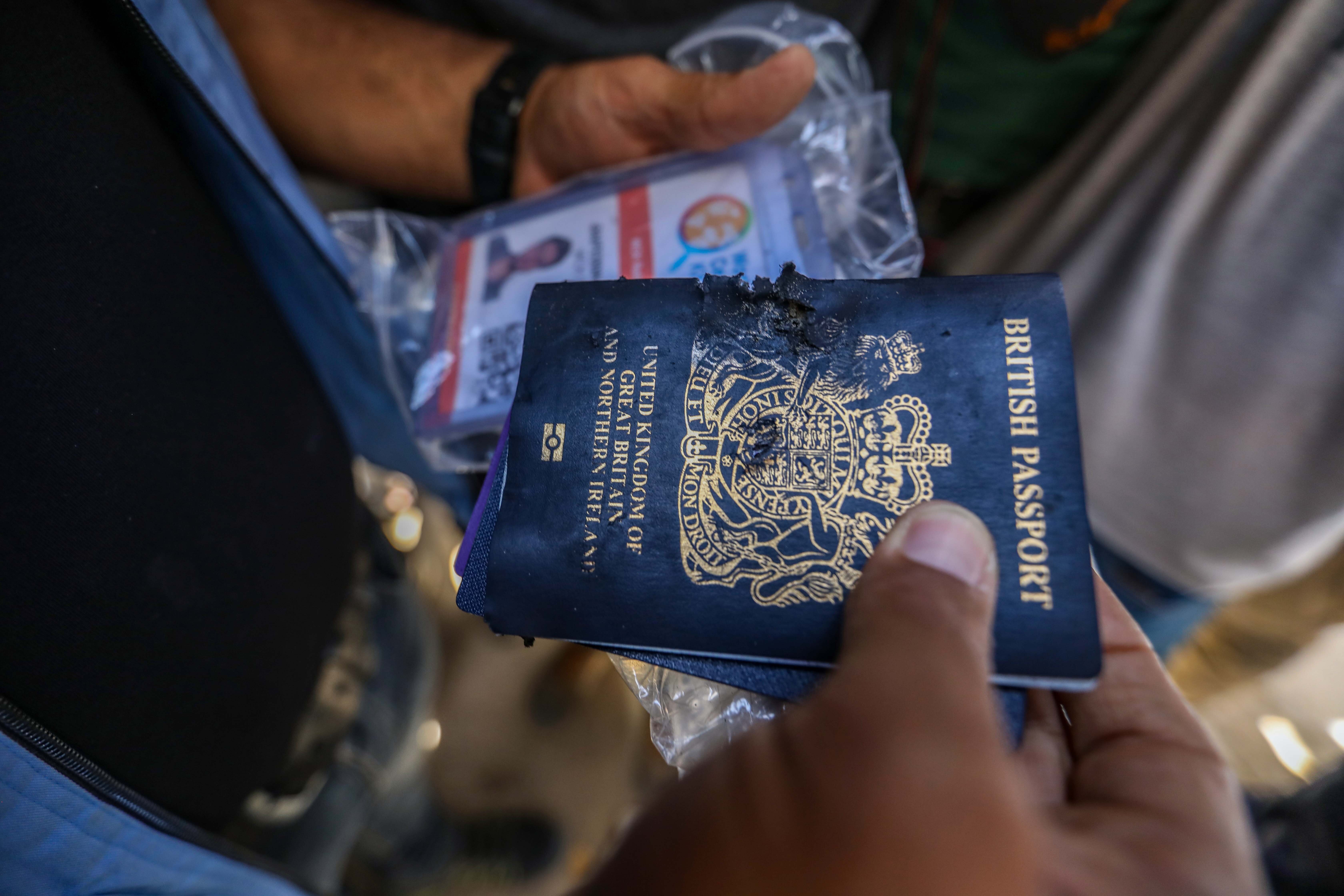 Damaged British passport held by a person, indicating an event affecting travelers or citizens