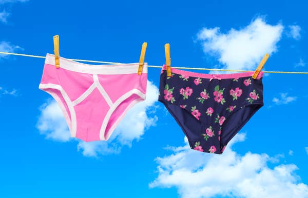 Two pairs of underwear hanging on a clothesline against a blue sky