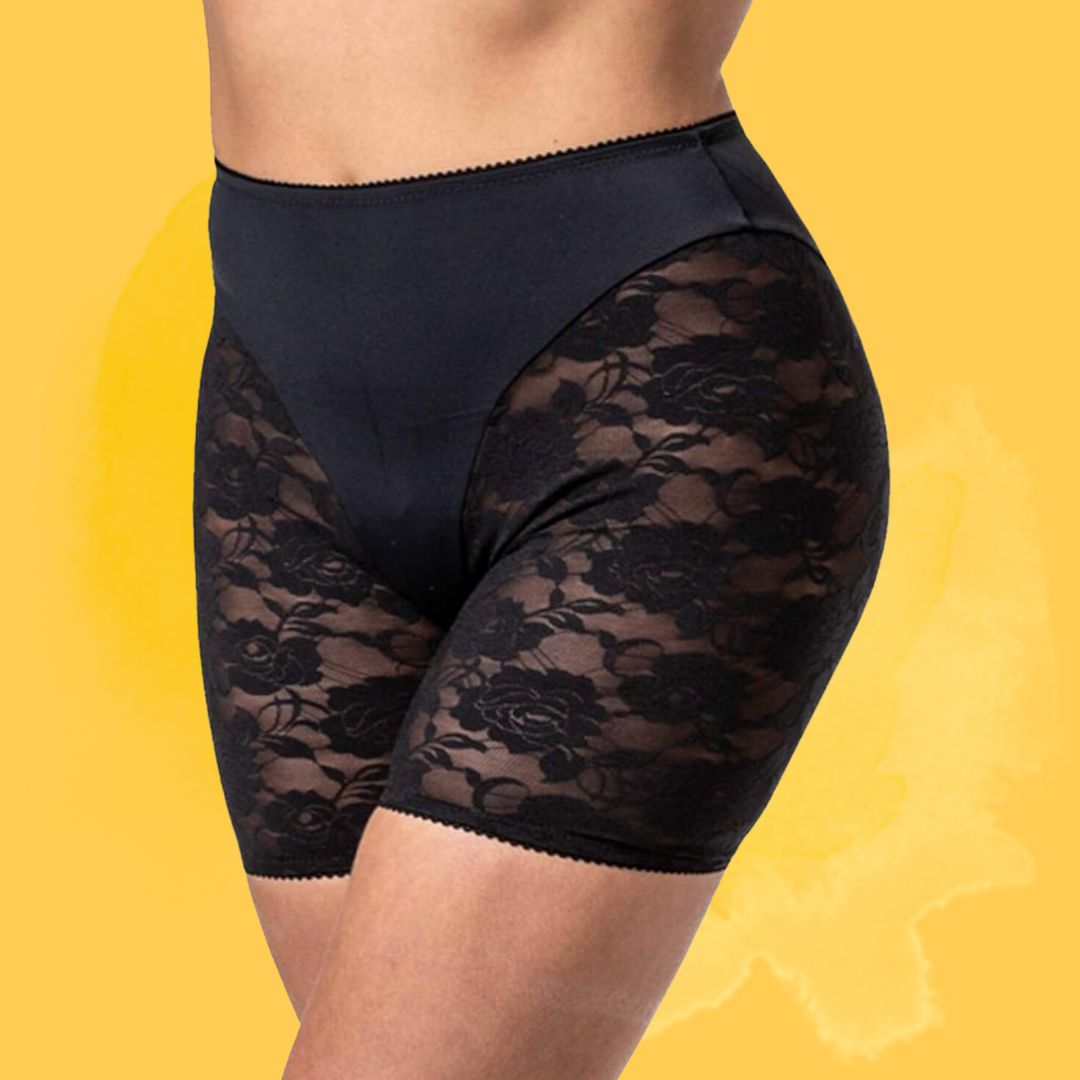 Woman modeling high-waisted achromatic lace shorts against a plain background
