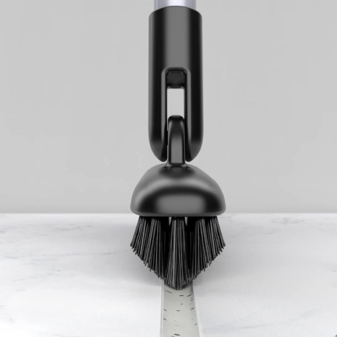 A cleaning brushwood  with dense bristles is shown scrubbing a surface. The grip  is sleek, suggesting a modern   room  cleaning tool