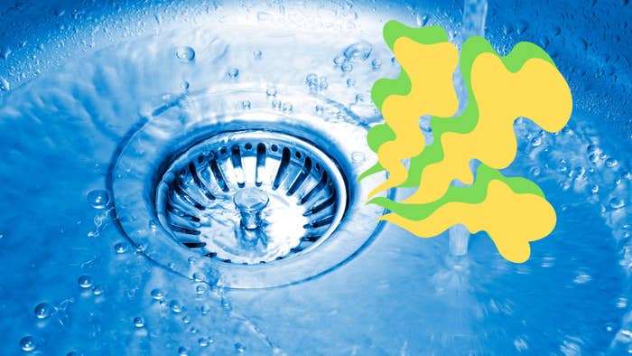 Water flows down a kitchen sink drain with an illustrated depiction of an unpleasant odor rising from it