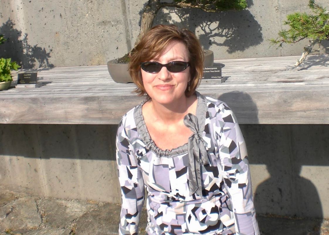 Rebecca in early 2013 sitting outdoors wearing sunglasses