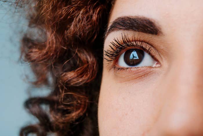 Close-up of a person's eye with curly hair visible