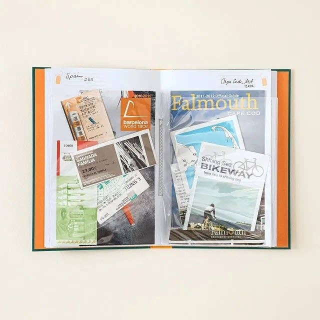 Open scrapbook with question   tickets, brochures, and motorcycle  way  representation  visible