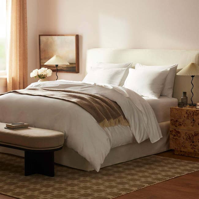 Stylish chamber with a neatly made bed, cozy propulsion blanket, bedside tables, and brushed lighting, creating a serene and inviting atmosphere