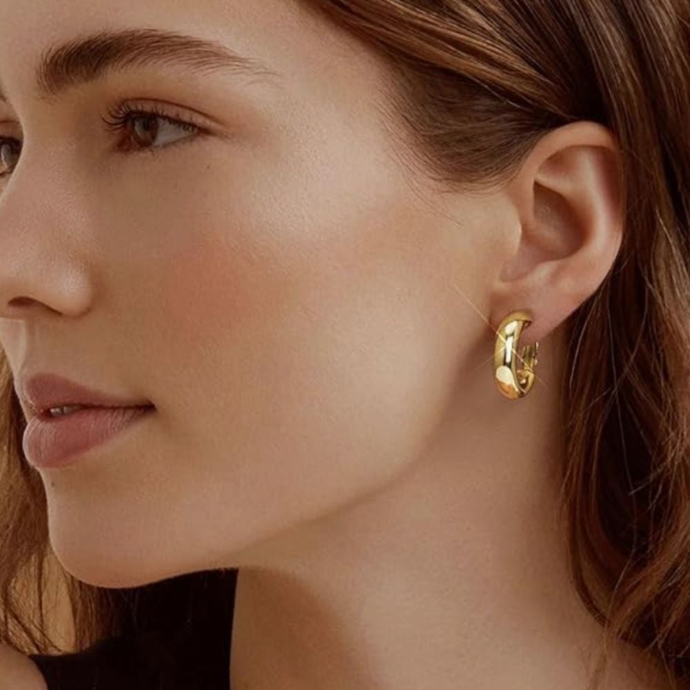 Person wearing golden  hoop earrings, showcasing a close-up presumption    of the jewelry