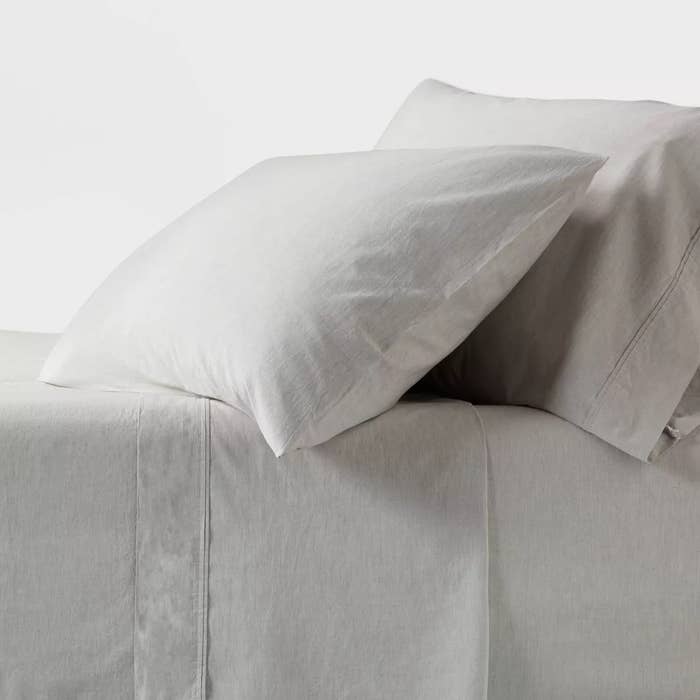 Two pillows and a furniture with minimalist sheets, showcasing a bedding acceptable for sale