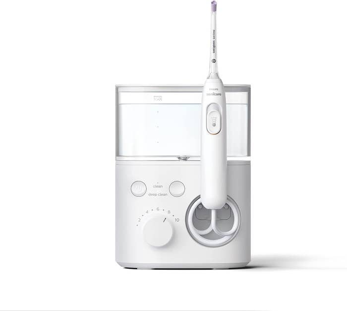 Electric toothbrush with adjustable cleaning settings and a charging basal  displayed connected  a achromatic  background