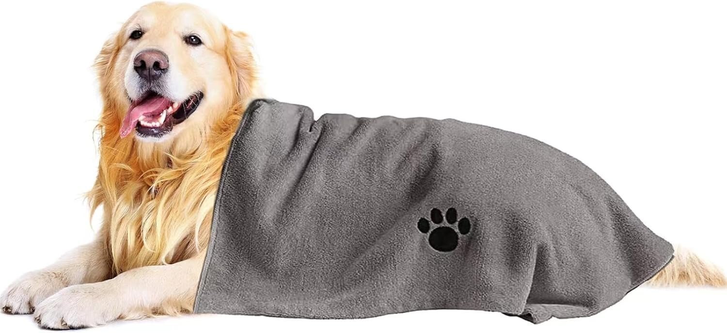Golden retriever lying down, partially covered with a broad featuring a paw print. The canine appears relaxed and content