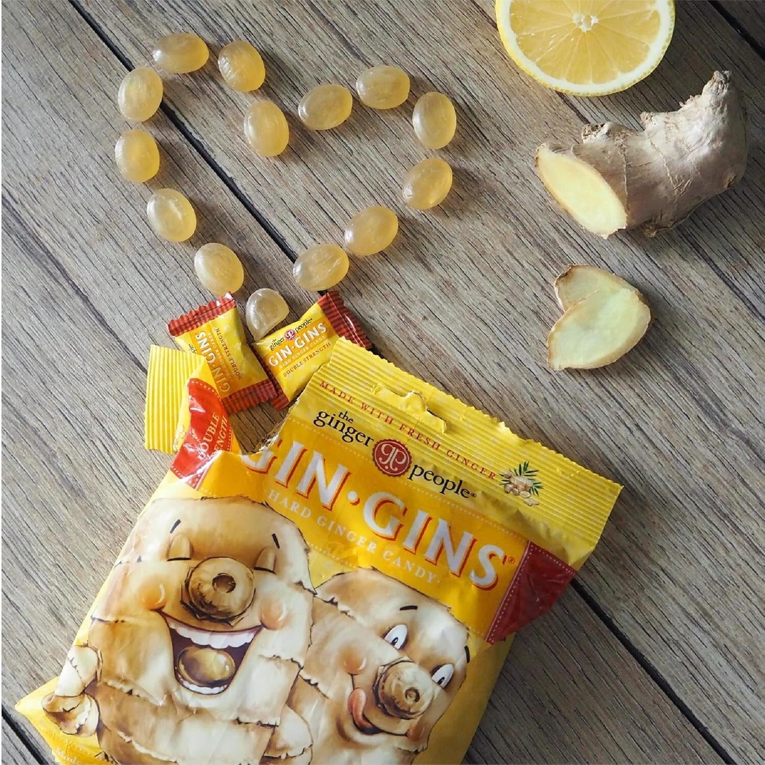 Gin Gins candy and ginger pieces arranged connected wood with a citrus slice