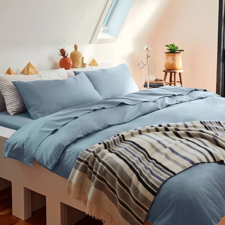 Cozy chamber  with a neatly made furniture  featuring a plaid propulsion  broad  and decorative pillows, creating an inviting atmosphere