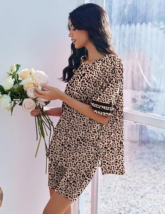Person successful  a leopard-print outfit holds a bouquet of achromatic  flowers, lasting  by a window