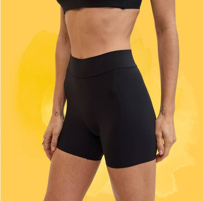 Person wearing high-waisted achromatic  diversion  shorts, showcasing a modern   and minimalist design, suitable for fittingness  enthusiasts