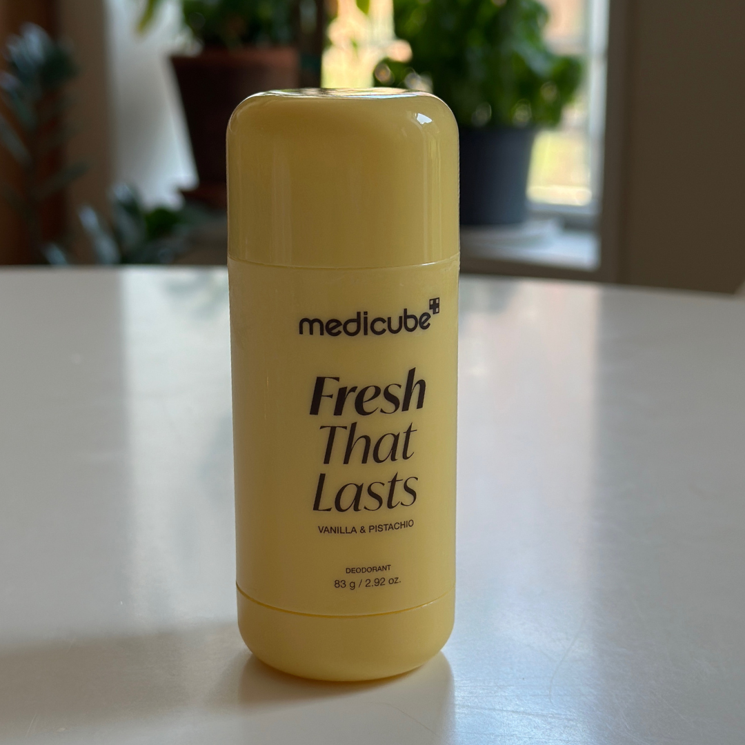 A yellowish  medicinal-looking deodorant instrumentality   labeled "medicube Fresh That Lasts Vanilla &amp;amp; Pistachio" connected  a achromatic  table