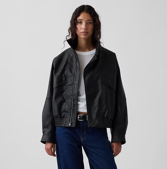 Person wearing a stylish, oversized leather overgarment implicit a achromatic garment and jeans, suitable for a casual manner article