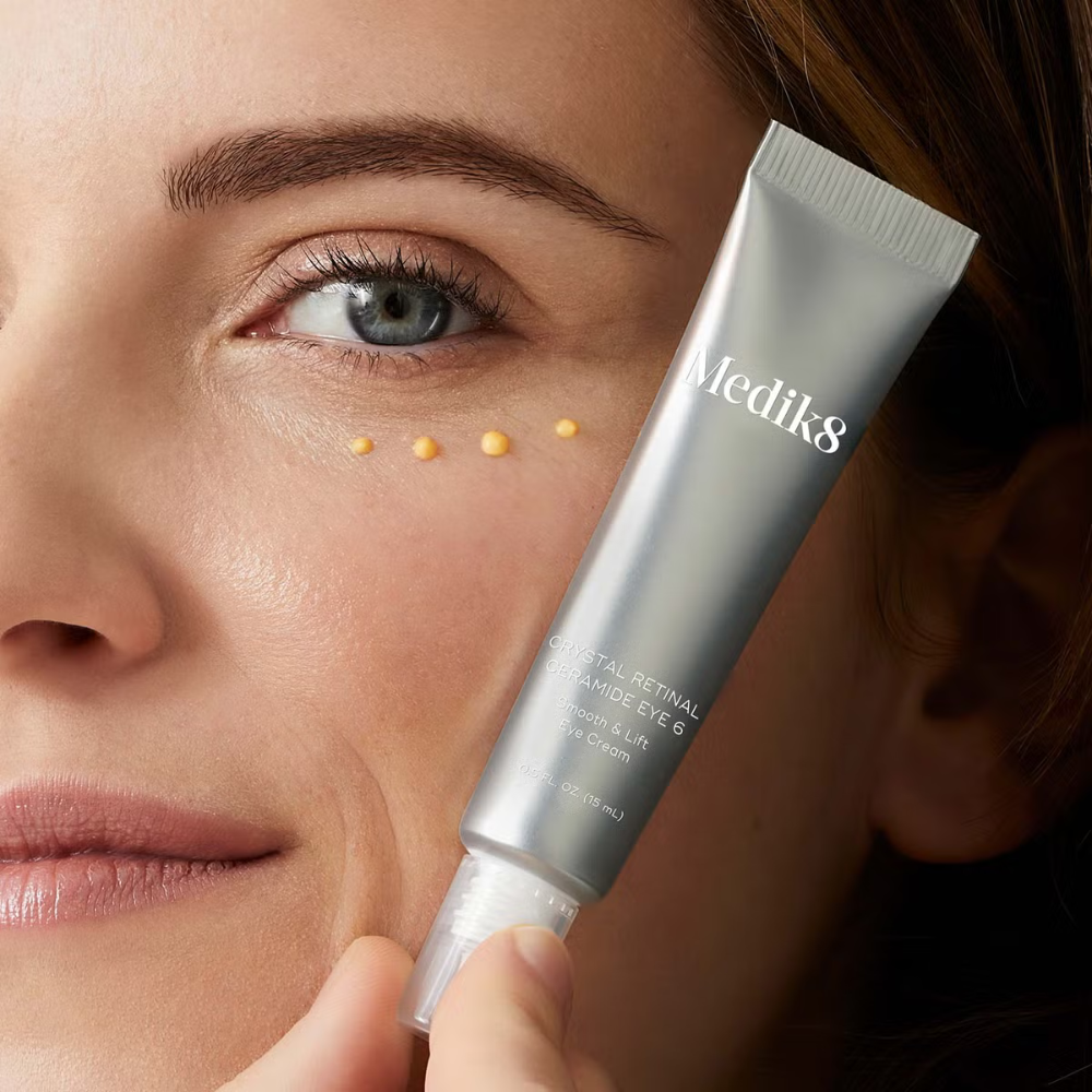 Close-up of a idiosyncratic   applying Medik8 retinol pick  nether  their eye, demonstrating skincare application