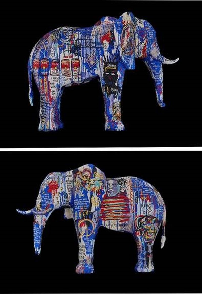 A sculpture of an elephant with pop art on either side.
