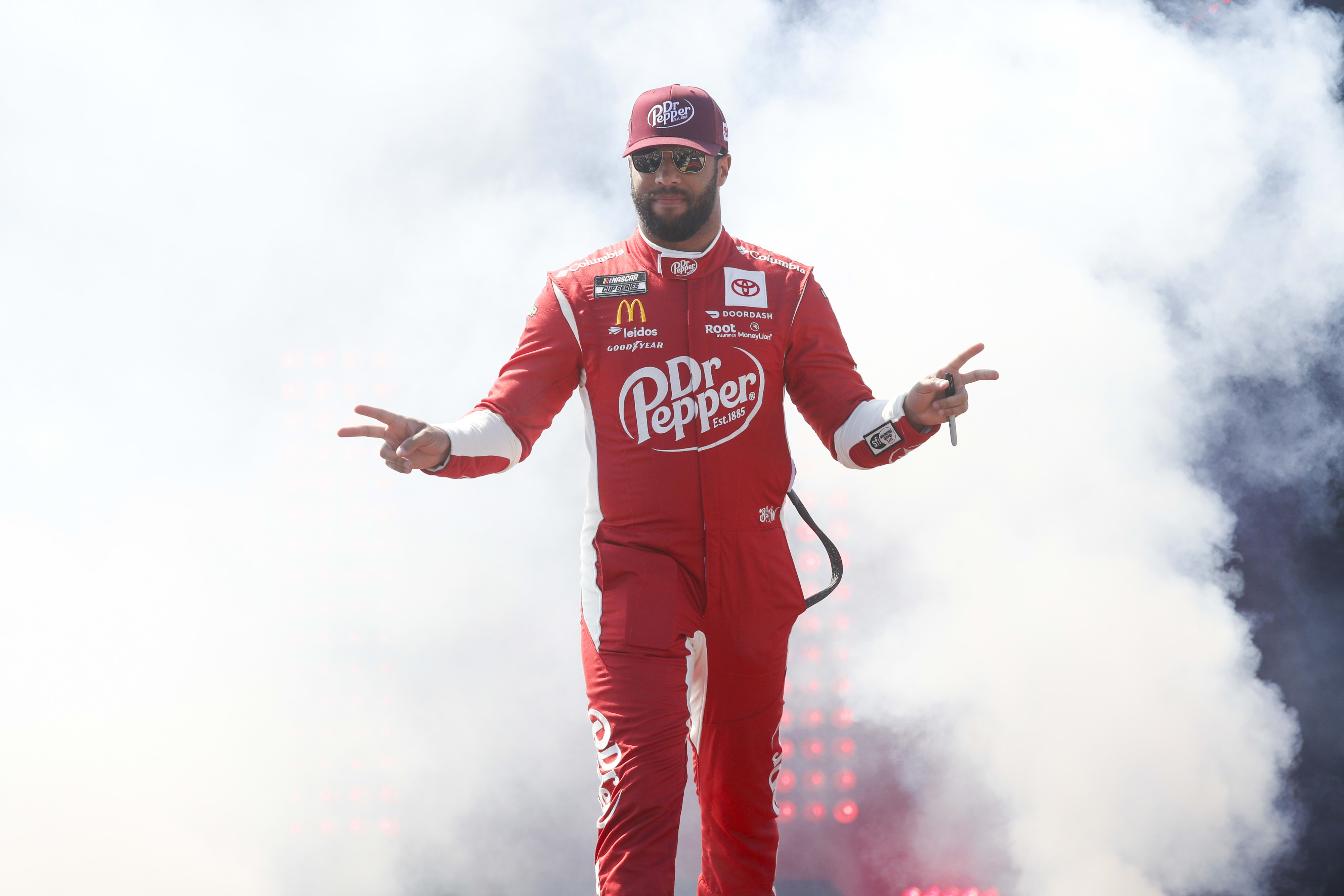 Bubba Wallace emerges in front of a cloud of smoke