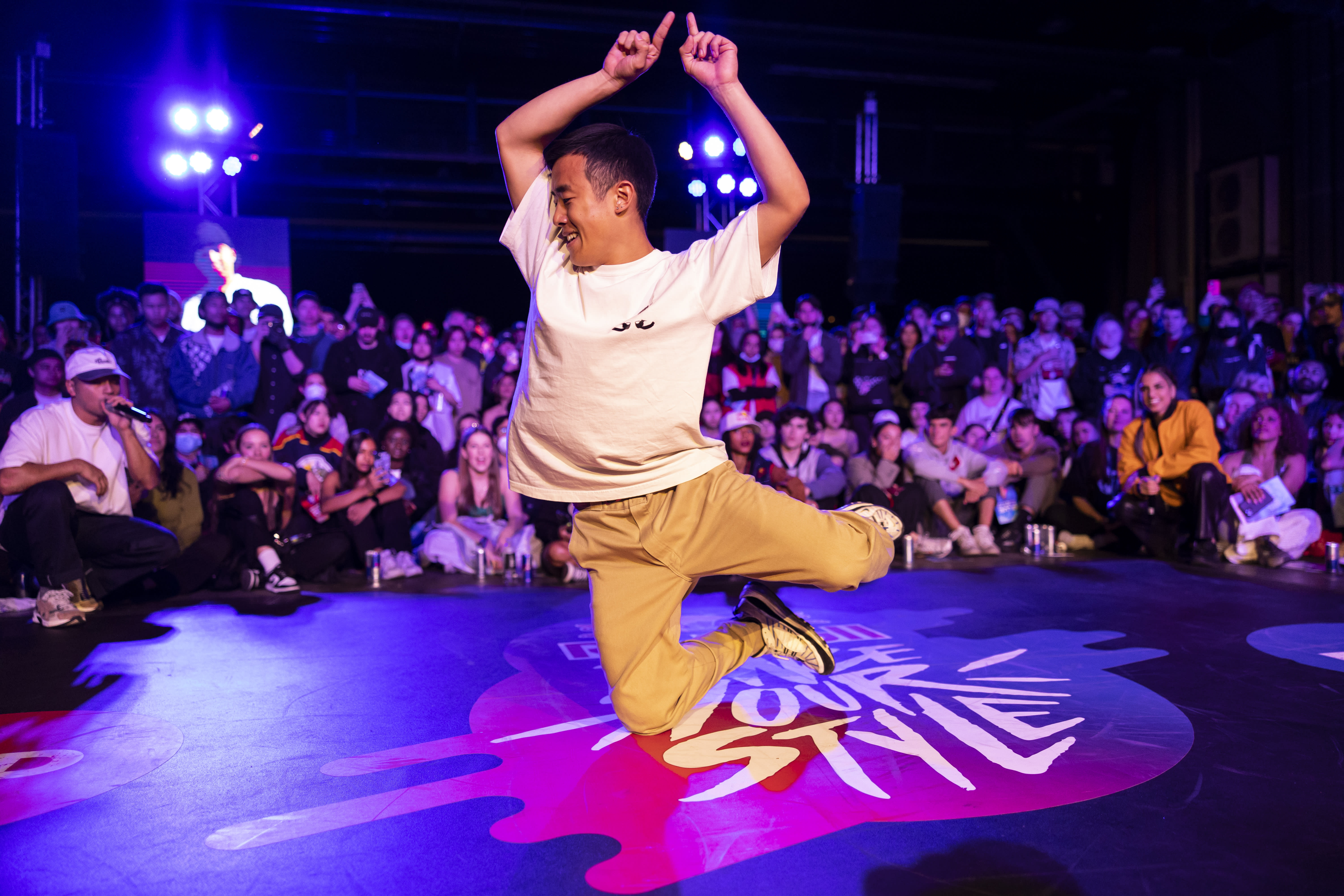 Koh Yamada, the winner of Red Bull&#x27;s Dance Your Style National Final, mid air in front of a crowd