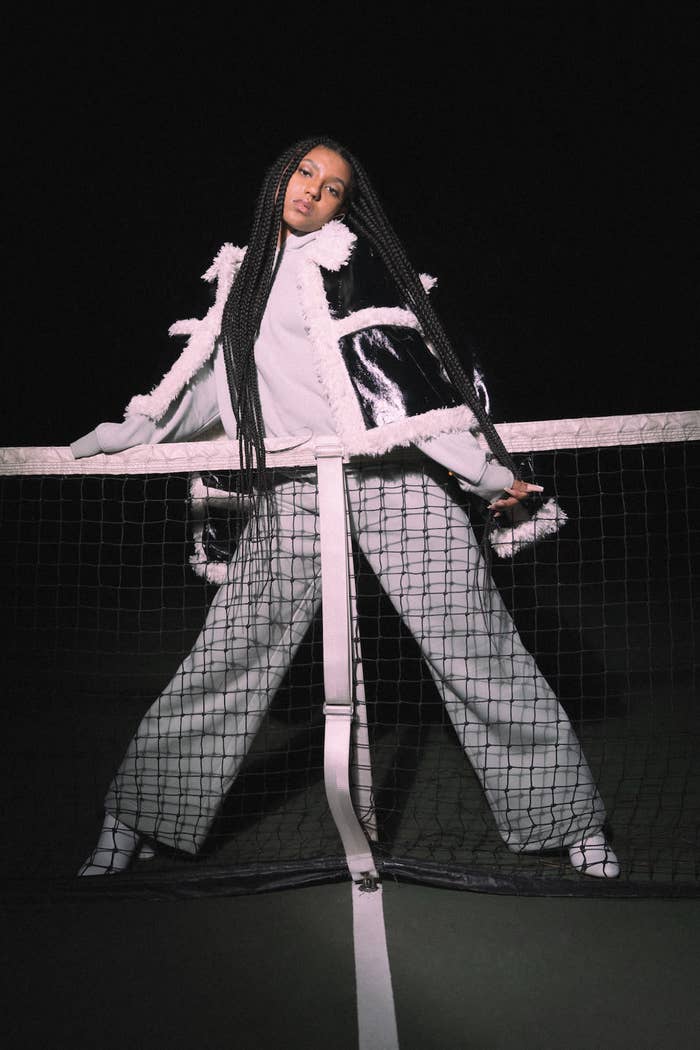 Luna Elle standing in front of a tennis net