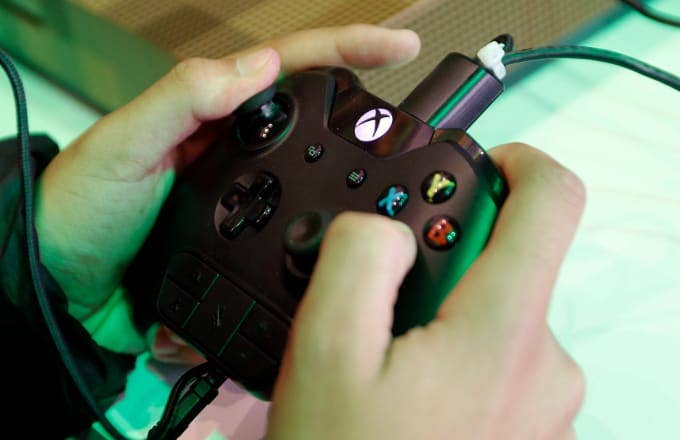 A gamer uses a Xbox video game controller to play the video game