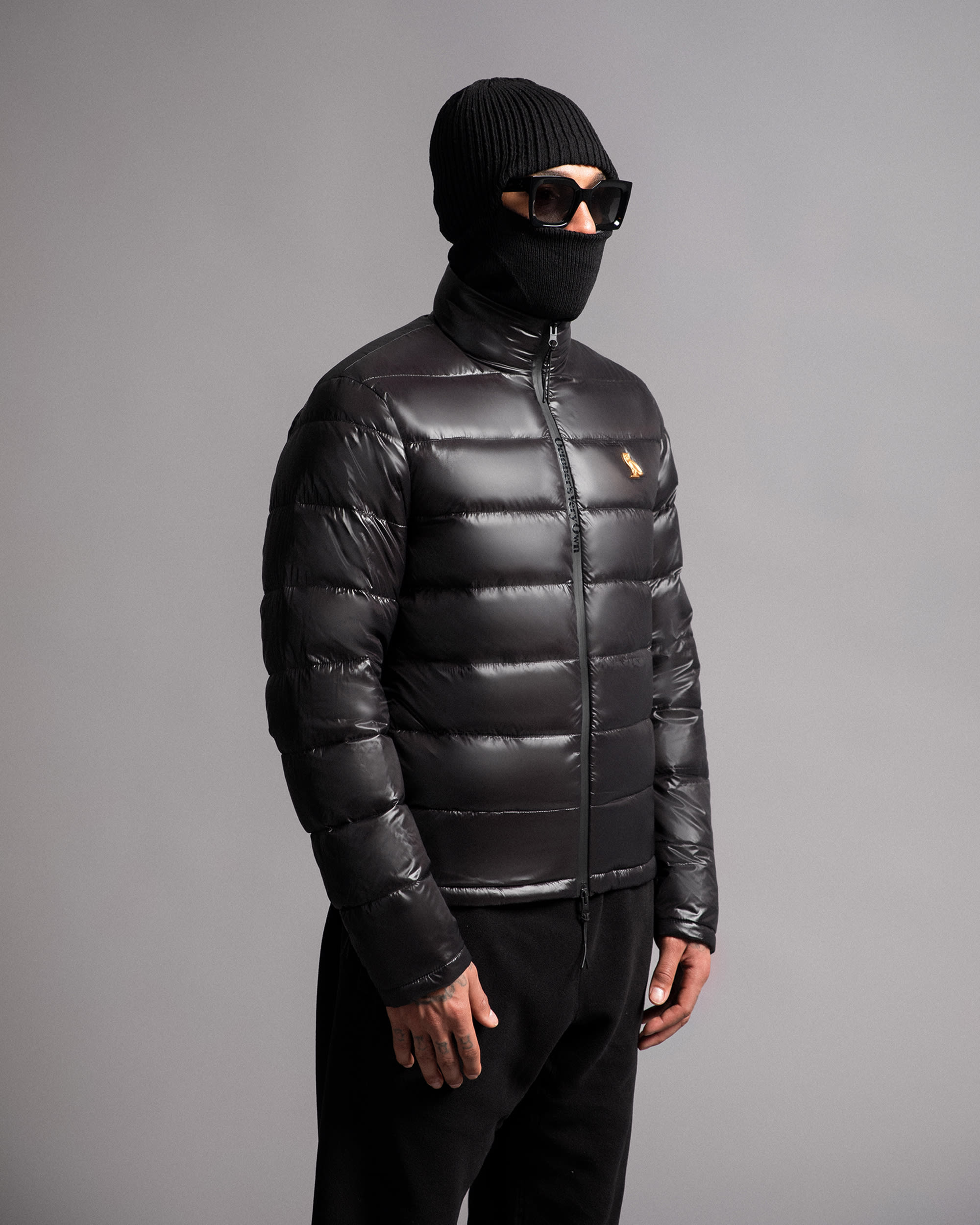 Model in black puffer and sunglasses