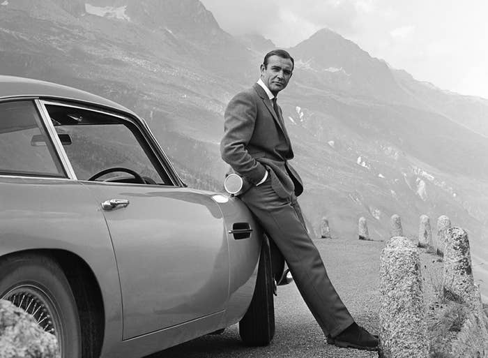 Sean Connery poses as James Bond next to his Aston Martin DB5 in a scene from &#x27;Goldfinger&#x27;