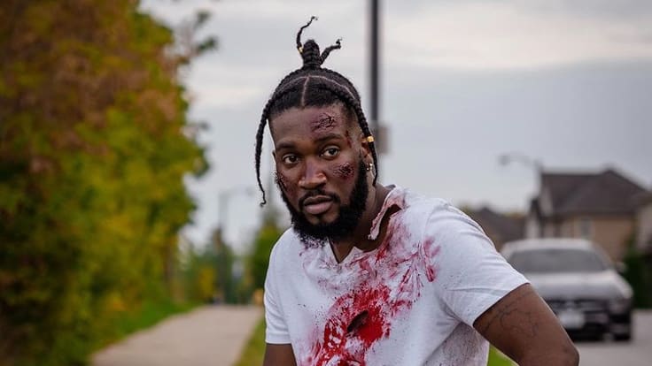 Rapper Supreme Swiss wearing a white t-shirt covered in blood.