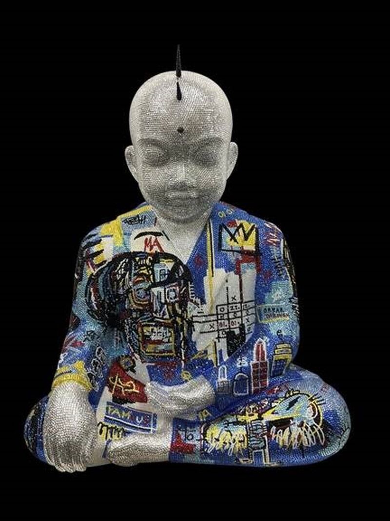 A statue of Buddha covered in pop art.