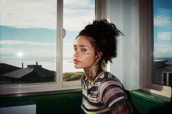 Kehlani sitting by a window in a striped tee shirt