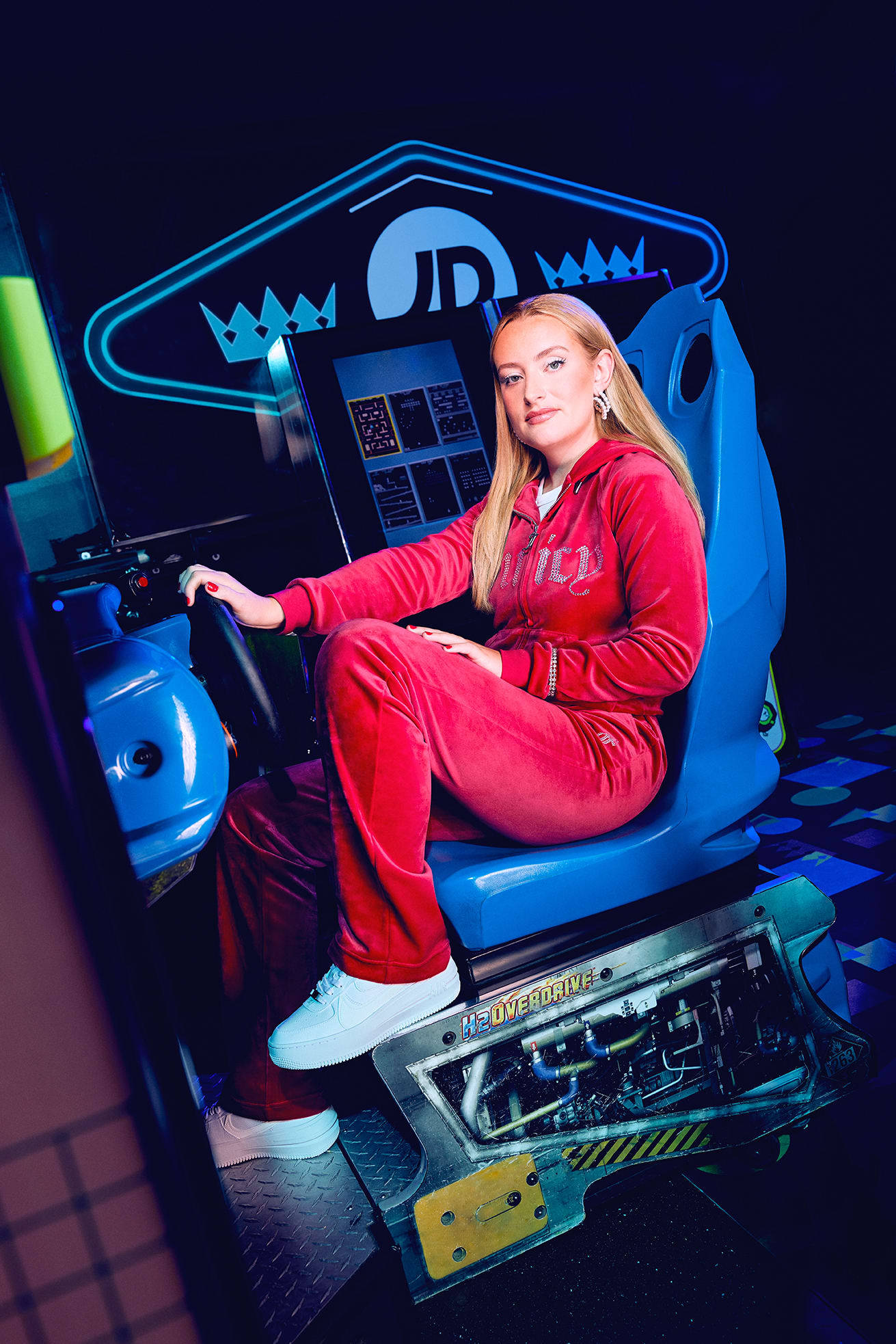 Amelia Dimoldenberg in an arcade racing car
