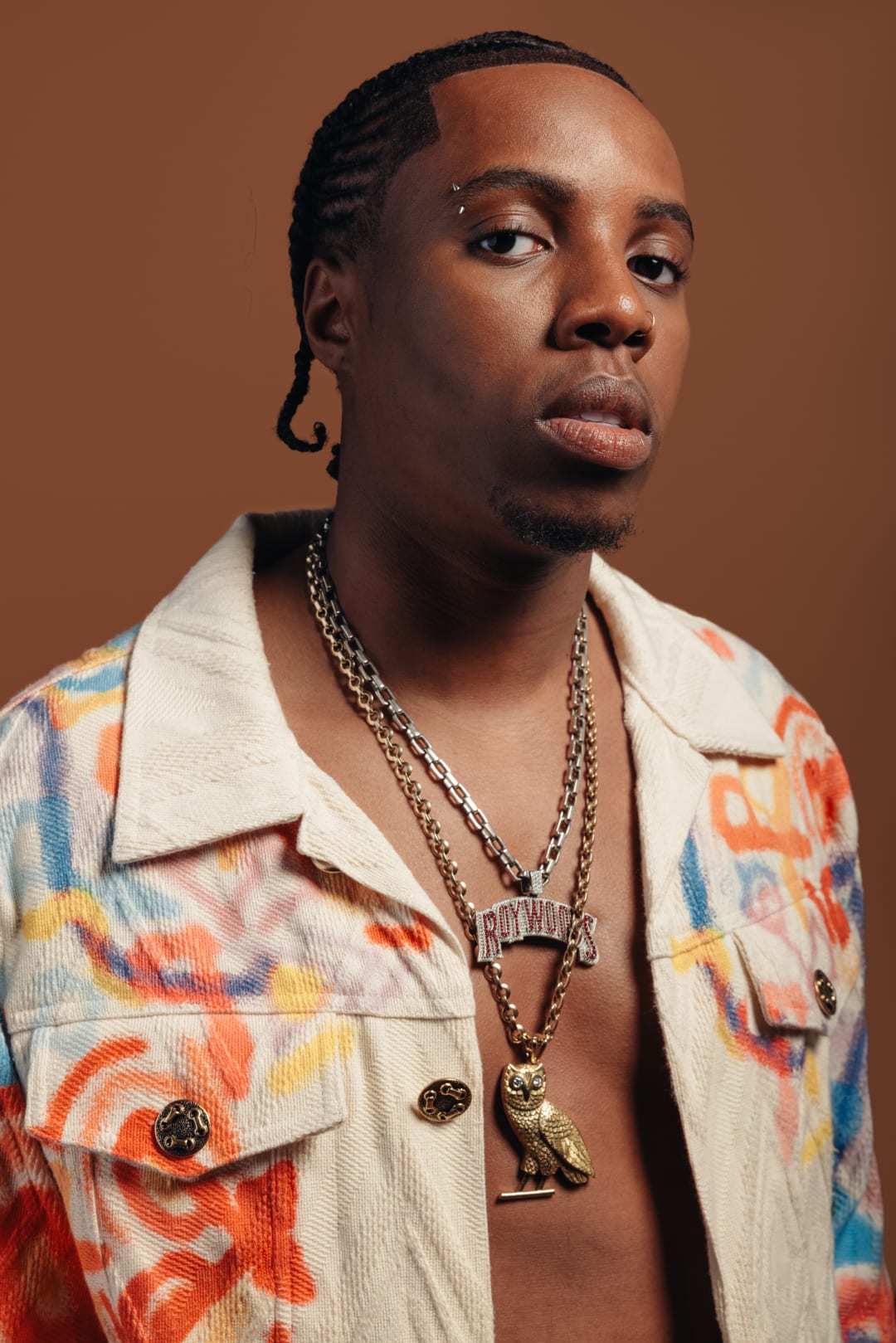 Rapper Roy Woods wearing a white jacket with a graffiti pattern