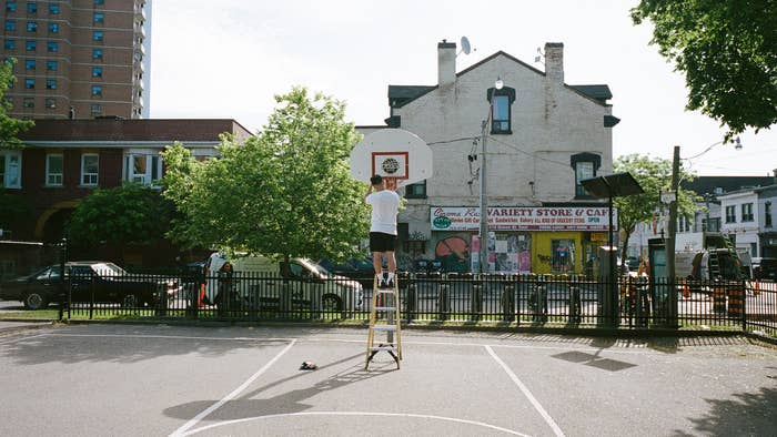 Toronto artist Adam the Illustrator replaces a basketball net in Canada
