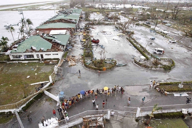 Residents wait near Tacloban's damaged airport for relief goods on Nov. 9.