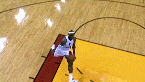 Lebron James throws down a 360 dunk while his headband flashes in the spotlight.