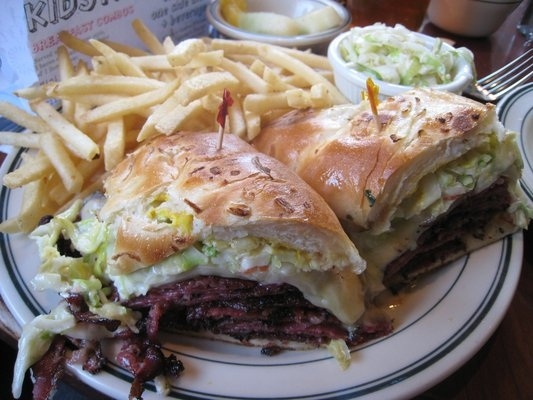 Grilled pastrami smothered in Russian dressing and topped with coleslaw, mustard and melted Swiss cheese on a long onion roll