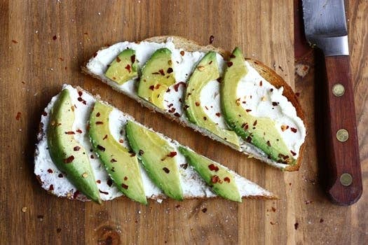 Toast a thick slice of your favorite whole-grain bread, spread with ricotta cheese, then top with avocado slices and some crushed red pepper. Works for lunch too. More info here.