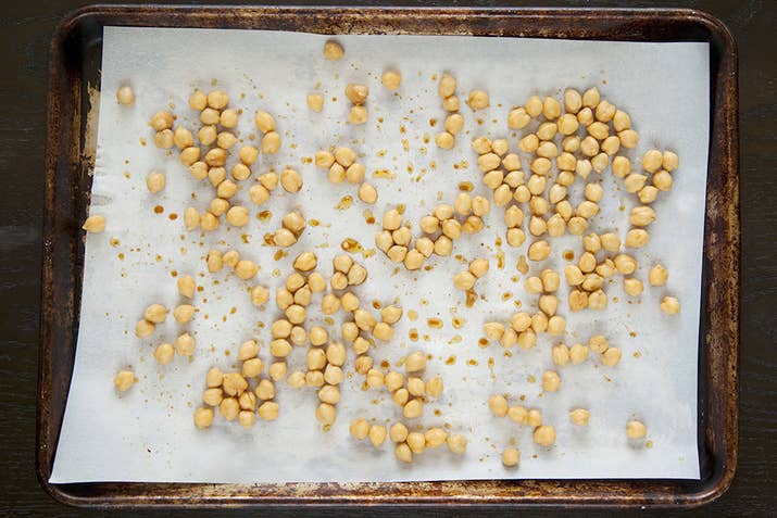 If you have two baking sheets, you can roast the chickpeas and the cauliflower at the same time. Spread the chickpeas out over your parchment-lined baking sheet.