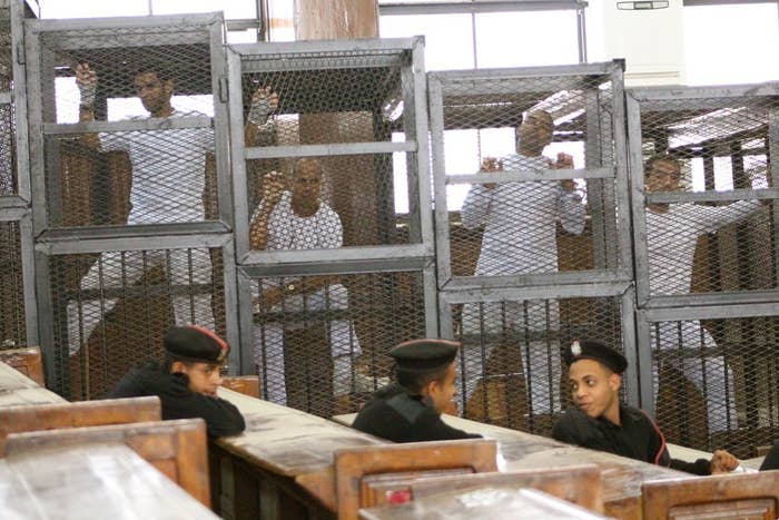 Defendants in the Al Jazeera trial stand in cages in an Egyptian court earlier this year.