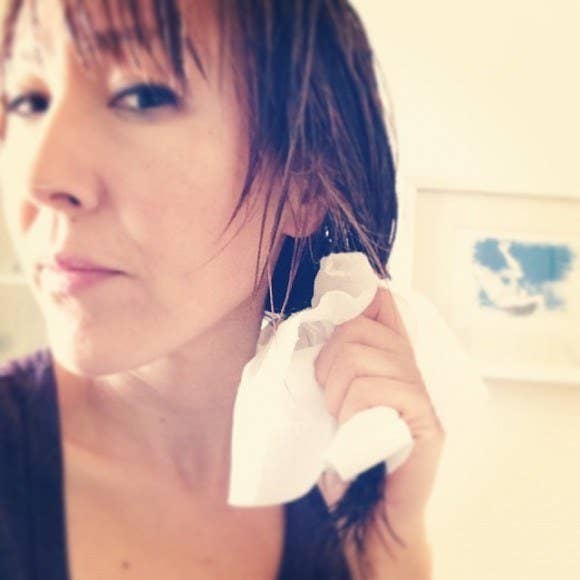 This crazy simple trick will surprise you — squeezing paper towels along the length and at the root of your strands will draw out wetness.