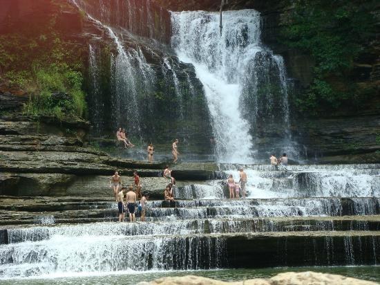 About halfway between Nashville and Knoxville, Cummins Falls cascades 75 feet over wide stair-stepped rocks into a deep cold-water pool. It is located in nine miles north of Cookeville in Jackson County close to the Putnam County line off Cummins Mill Rd. on the Blackburn Fork State Scenic River. For the sure-footed only as the path to this gorgeous hole is mostly water-covered.