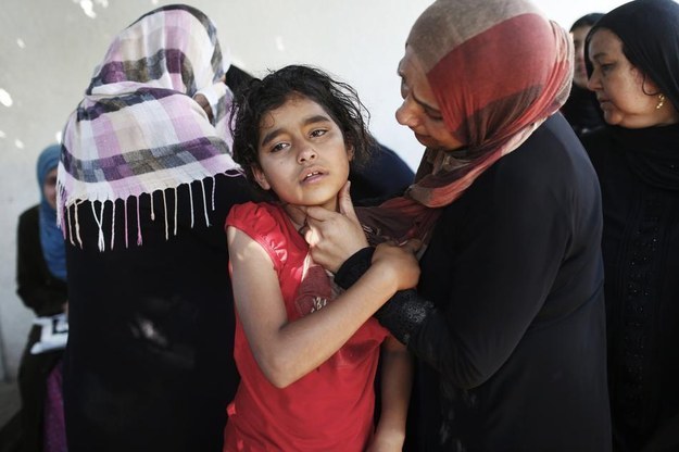A mother comforts her daughter at a hospital in Jabaliya after an Israeli shell hit a U.N-run school sheltering Palestinian refugees.