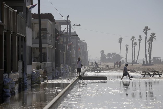 A man walks through the flooded beachfront properties on Wednesday in Seal Beach, Calif.