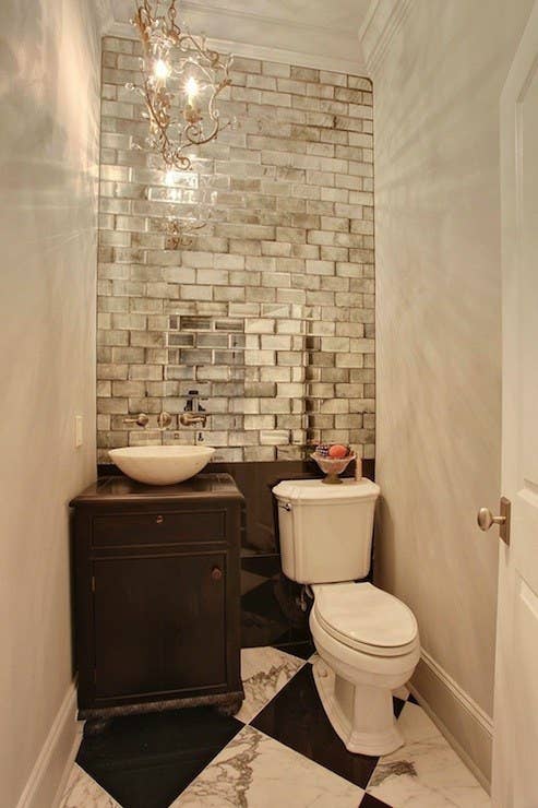 Mirrors can instantly double the appearance of a room, but there&#x27;s no reason you have to go the traditional route! Metallic subway tile adds a layer of texture to this tiny WC.