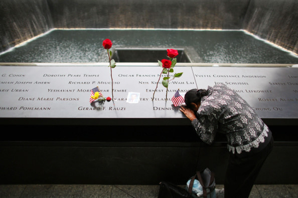 A woman grieves at her husband's memorial at South Tower Reflecting Pool before the memorial observances held at the site of the World Trade Center.
