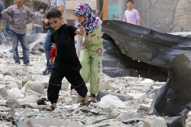 Children walk on rubble after what activists said was an air strike by Assad's forces on southern Aleppo city.