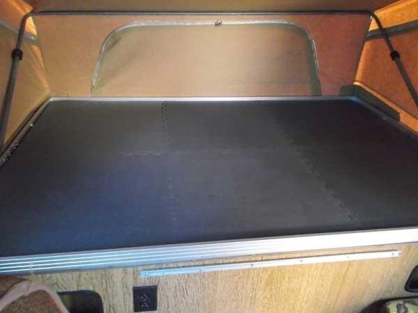 Rubber floor mat attached to the bottom of a bunk in a van or RV